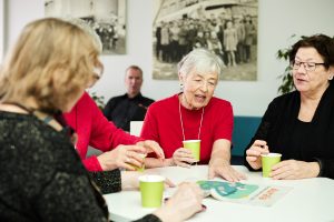 Personer med Aurala-tidningen och kaffekoppar i Aurala-lobbyn