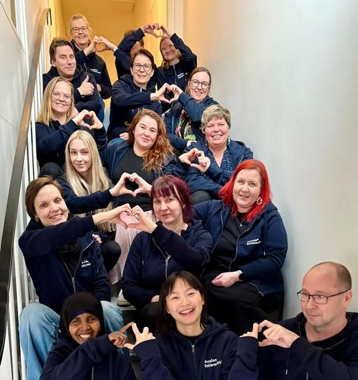 Auralan henkilökunta istuu portailla