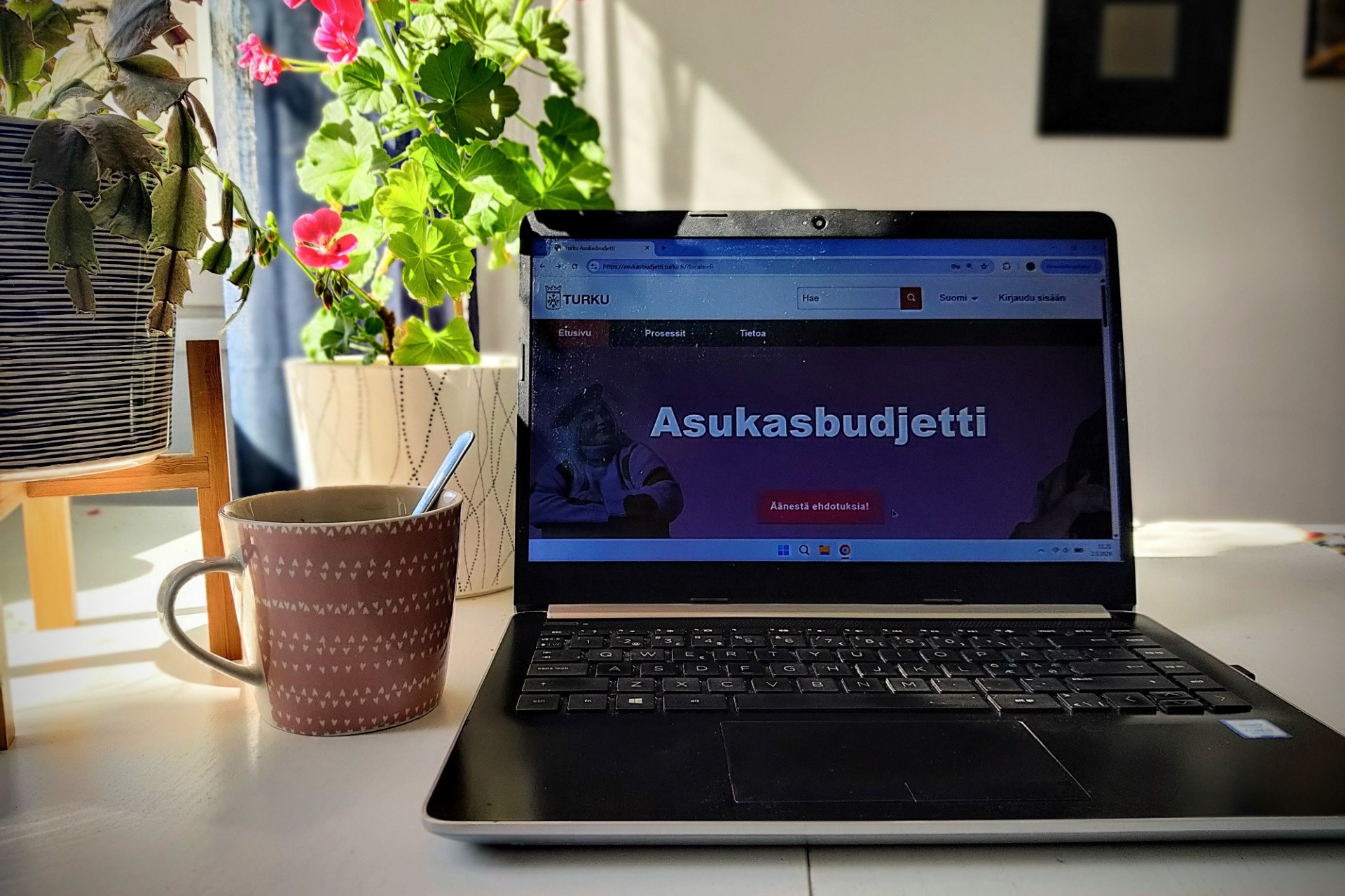 kannettava tietokone pöydällä. koneen näytöllä näkyy teksti "asukasbudjetti"